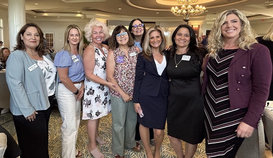 A group of executive women posing for a photo. 